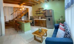 ein Wohnzimmer mit einem blauen Sofa und einer Küche in der Unterkunft Villas Flakis, Luna in Monteverde Costa Rica