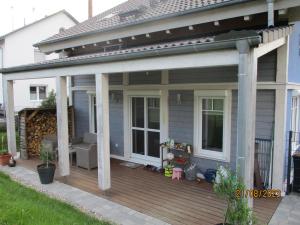 una terraza de madera con una sombrilla de patio en una casa en Ferienhaus Am Pfingstborn 