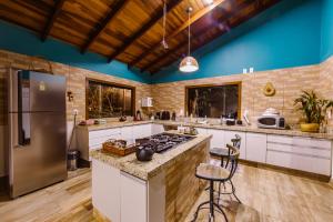 a large kitchen with a stove and a refrigerator at Casa Rosa - Terra Dourada, Paraíso na Natureza, piscina natural, Wi-Fi in Brasilia