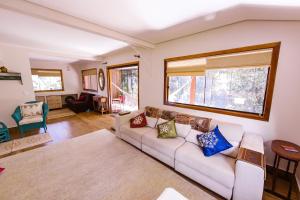 sala de estar con sofá y ventana en Casa Rosa - Terra Dourada, Paraíso na Natureza, en Brasilia