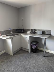 eine Küche mit einer Theke, einem Waschbecken und einem Tisch in der Unterkunft Kings Head in Chepstow