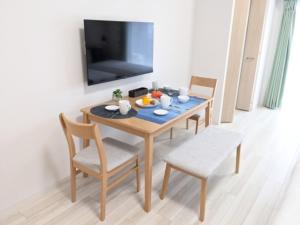 a dining room table with two chairs and a television at ESLEAD HOTEL Namba Daikokucho - Vacation STAY 86025v in Osaka