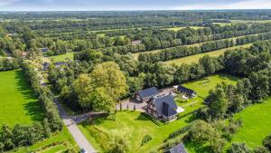 una vista aérea de una casa en medio de un campo en Luxurious nature stay in Friesland with jacuzzi, en Veenklooster
