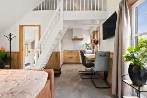 a room with a bed and a dining room with a staircase at Luxurious nature stay in Friesland with jacuzzi in Veenklooster