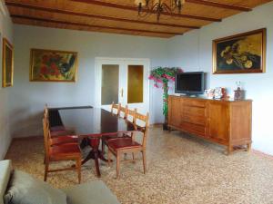 a living room with a dining room table and a tv at Casa en la sierra de Madrid para grupos grandes in Madrid