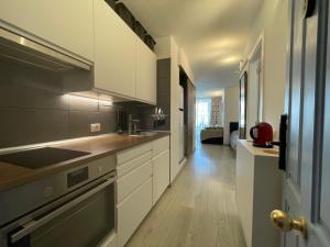 een keuken met witte kasten en een fornuis met oven bij Apartamento con Piscina en Golf del Sur in San Miguel de Abona