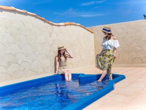ArazatoにあるOcean's Resort Villa Vorla - Vacation STAY 36094vの二人の女が水の中に立ってスイミングプールに立っている