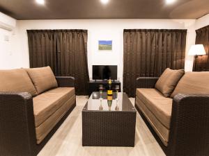 ein Wohnzimmer mit 2 Sofas und einem Tisch in der Unterkunft Ocean's Resort Villa Vorla - Vacation STAY 36094v in Arazato