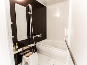 uma casa de banho branca com uma banheira branca e um espelho. em Ocean's Resort Villa Vorla - Vacation STAY 36094v em Arazato