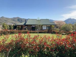 a house in a field with red flowers at Villa Ashitani - Vacation STAY 08864v in Nantan city