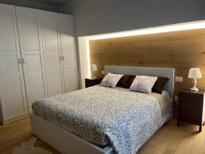 1 dormitorio con 1 cama grande y cabecero de madera en Appartamento Isa, en Tarvisio
