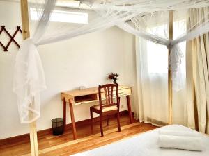 a bedroom with a desk and a chair and a window at Villa ChezSoa, Antananarivo in Antananarivo