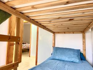 uma cama num quarto com tecto em madeira em Little Home em Puerto del Rosario