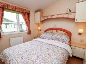 - une chambre dotée d'un lit avec un couvre-lit floral dans l'établissement Bryn Vista, à Aberystwyth