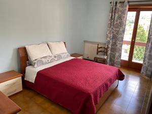 1 dormitorio con 1 cama con manta roja y ventana en La Fiorita Aosta en Aosta