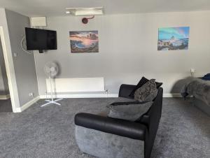 ein Wohnzimmer mit einem Sofa und einem TV in der Unterkunft Kings Head in Chepstow