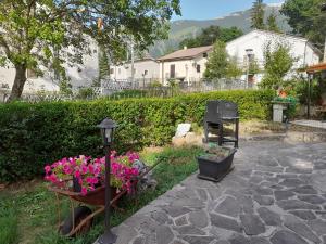 a garden with flowers and a street light and a grill at Gabriella in SantʼEufemia a Maiella