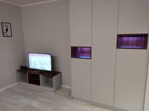a room with a television on a table and two windows at Apartament Curie in Zabrze