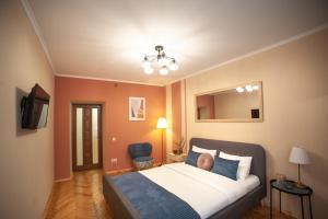 リヴィウにあるRomantic Suite, 3mins to Rynok Squareのベッドルーム1室(ベッド1台、鏡、椅子付)