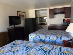 a hotel room with two beds and a flat screen tv at Fort Worth TX Downtown East in Fort Worth