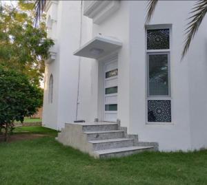 a white house with stairs and a window at Juman B&B in Seeb