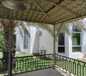 a patio with a pergola in front of a house at Juman B&B in Seeb