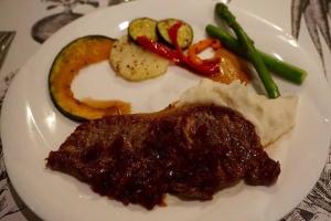 a plate of food with meat and vegetables on a table at Guesthouse Kreutzer in Chino