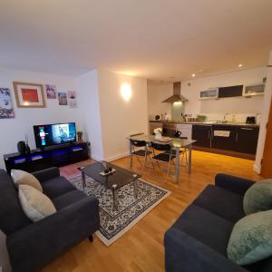a living room with a couch and a table and a kitchen at Fabulous one bedroom Apartment Sheffield City Centre in Sheffield