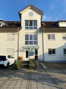 a white car parked in front of a house at Harmony Apartment, your holiday home in Rust with balcony & river-view, 5min to Europa-Park in Rust