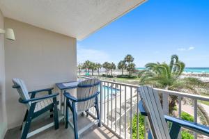 a balcony with a table and chairs and the beach at Destin on the Gulf 205 - Updated Gulf Front Property with Free Beach Service in Destin