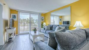 sala de estar con sofá azul y TV en Destin on the Gulf 201 - Beach Front Property, en Destin