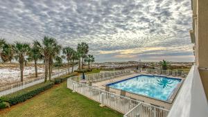a swimming pool on the side of a building with palm trees at Destin on the Gulf 201 - Beach Front Property in Destin