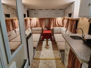 a living room with two couches in a trailer at Pilsētas glempings - "Gliemezis" in Valmiera