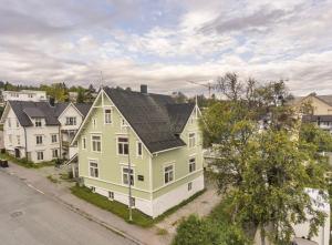 an aerial view of a yellow house with a black roof at One bedroom basement apartment in the city in Tromsø