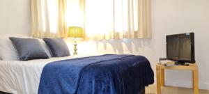 a bedroom with a bed with a blue blanket and a tv at Fabulous one bedroom Apartment Sheffield City Centre in Sheffield
