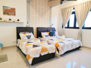 two beds sitting next to each other in a bedroom at Zuncy A37- Medini Legoland Puteri Harbour Iskandar Puteri in Nusajaya