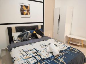 a bedroom with a large bed with a blue comforter at Zuncy A37- Medini Legoland Puteri Harbour Iskandar Puteri in Nusajaya