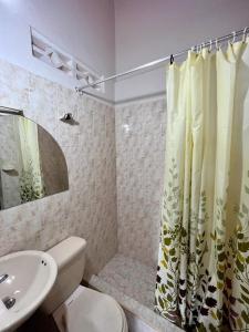 a bathroom with a toilet and a shower curtain at Hotel Los Balcones in Tocaima