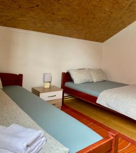 a bedroom with two beds and a wooden ceiling at Apartments Bozovic in Žabljak