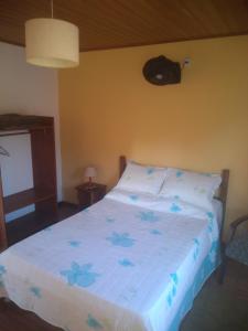 a bedroom with a bed with blue flowers on it at Chalés da Serra in São Pedro da Serra
