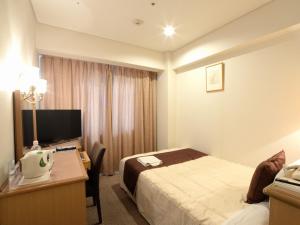佐世保市にあるSunwest Hotel Sasebo - Vacation STAY 22131vのベッドと机とパソコンが置かれたホテルの部屋