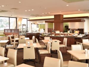 佐世保市にあるSunwest Hotel Sasebo - Vacation STAY 22131vのテーブルと椅子のあるレストランとカフェテリア