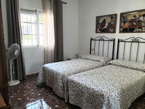 a bedroom with two beds and a window at La Caseja Rural in Ossa de Montiel