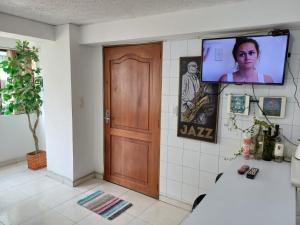 Habitación con puerta y TV en la pared en Apartamento Central En La Zona De Cable Plaza, en Manizales