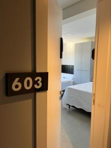 um quarto com uma cama e um relógio na porta em Loft com vista para Vila Germânica 603 em Blumenau