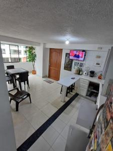sala de estar con mesa y TV. en Apartamento Central En La Zona De Cable Plaza, en Manizales