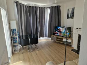 a living room with a tv and two chairs at A lovely one bedroom in Hither Green lane in London