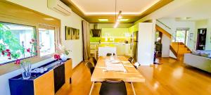 a dining room with a table and a kitchen at Avatonblue Villa Nafplio in Vivari