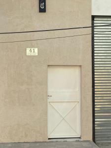 uma porta branca num edifício com um sinal por cima em Departamentos del Estero em Santiago del Estero