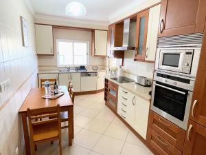 a kitchen with a table and a microwave and a stove at Praia Village AG in Vilamoura